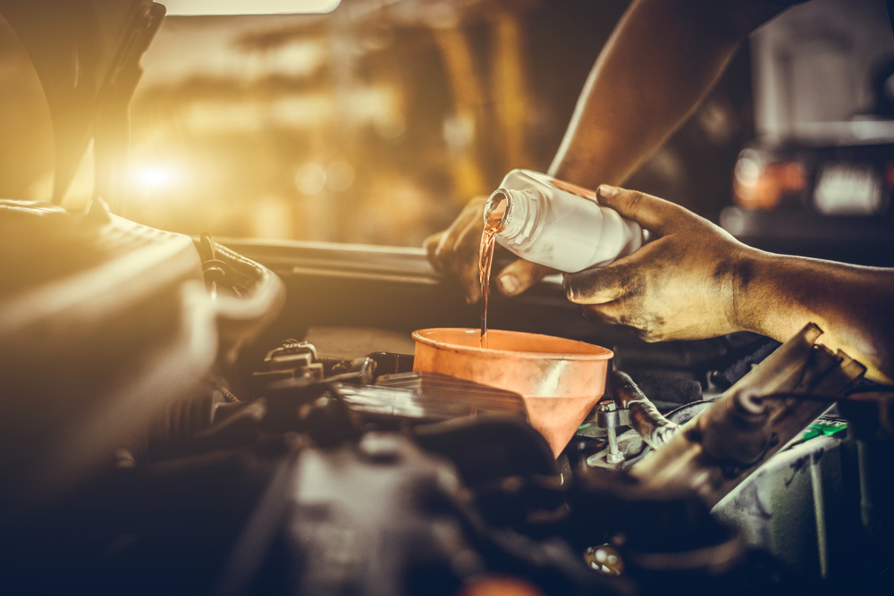 pouring oil in car engine